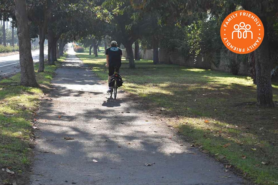 Bike rider on Victoria Avenue Bike Path.  Image stamped with Family Friendly Badge.